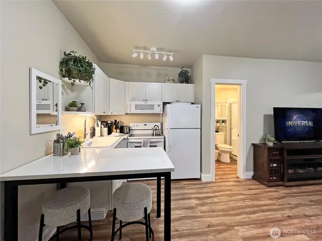 a kitchen with stainless steel appliances a table chairs and a refrigerator