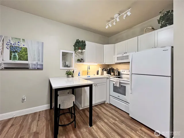 a kitchen with white cabinets and white appliances