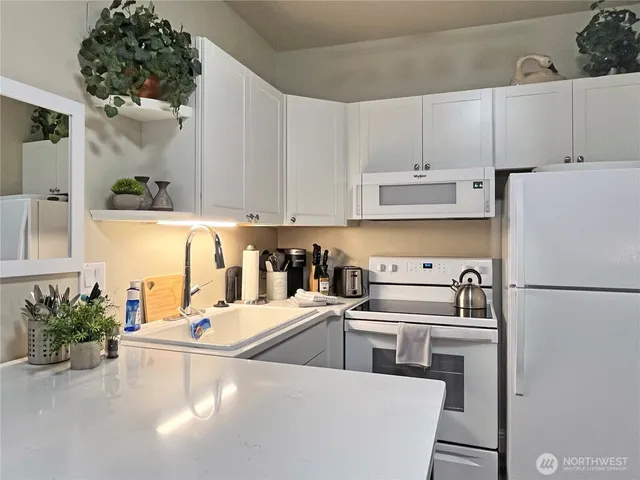 a view of a kitchen with sink and refrigerator