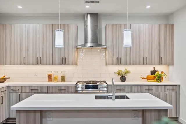 a kitchen with a sink a stove cabinets and counter space