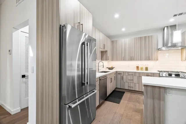 a kitchen with granite countertop a refrigerator and a sink