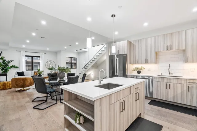 a kitchen that has a lot of cabinets and wooden floor