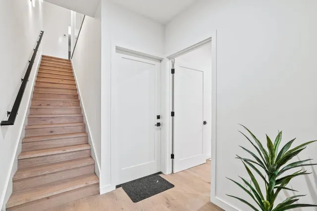 a view of a hallway with white walls and wooden floor