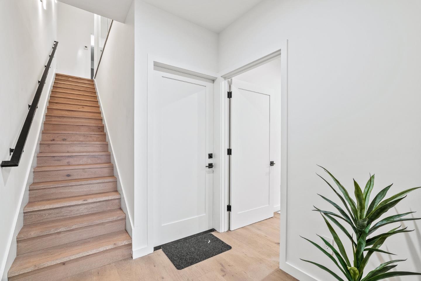908 Woodside Road Redwood City, CA 94061 - Photo 5 of 34 a view of a hallway with white walls and wooden floor