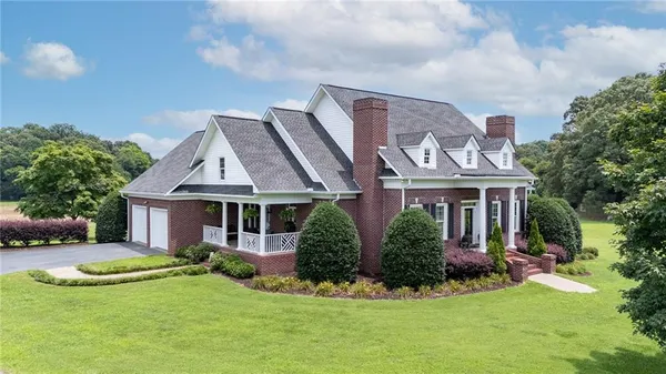 a front view of a house with a yard and potted plants