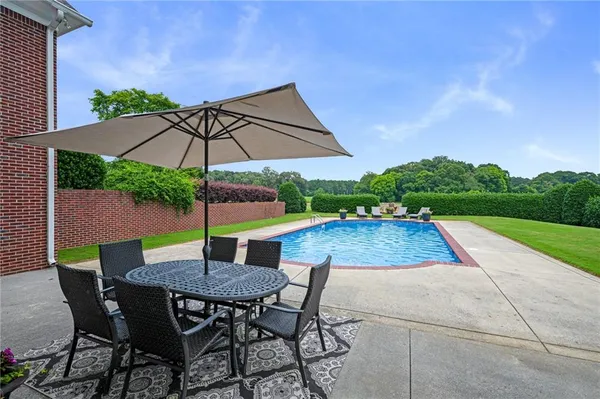 a kitchen with granite countertop a table chairs a sink and cabinets