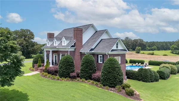 a view of a house with backyard sitting area and swimming pool