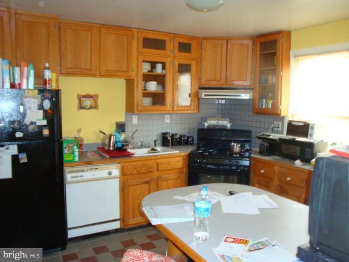 2713 Terrapin Road Silver Spring, MD 20906 - Photo 2 of 10 a kitchen with a sink stove and wooden cabinets