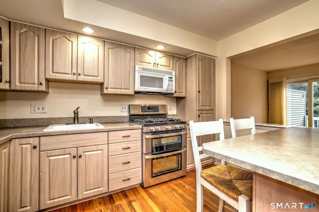 a kitchen with granite countertop a stove sink and cabinets