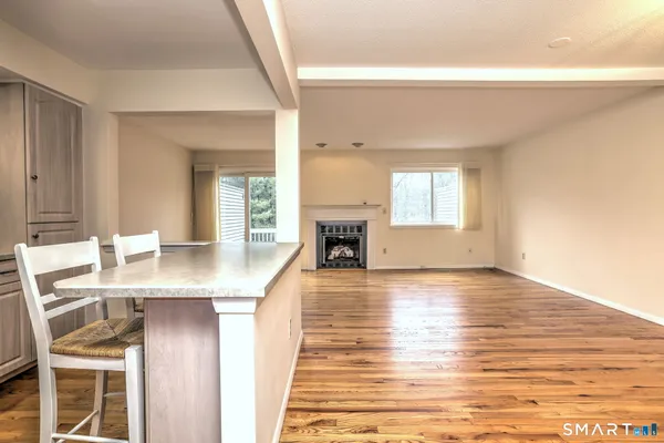 a living room with fireplace and wooden floor