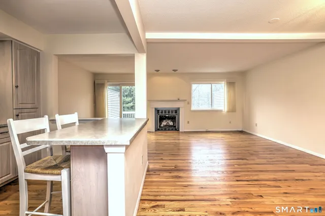 a living room with fireplace and wooden floor