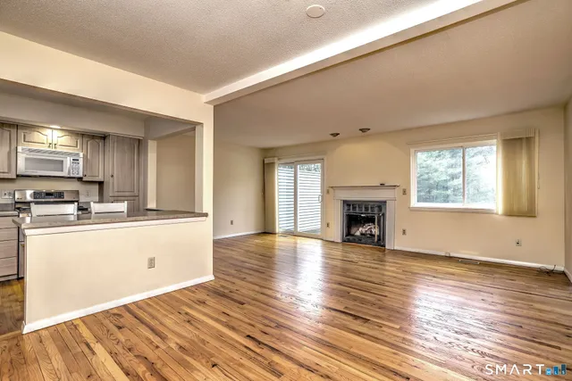 a view of a kitchen with wooden floor and a fireplace