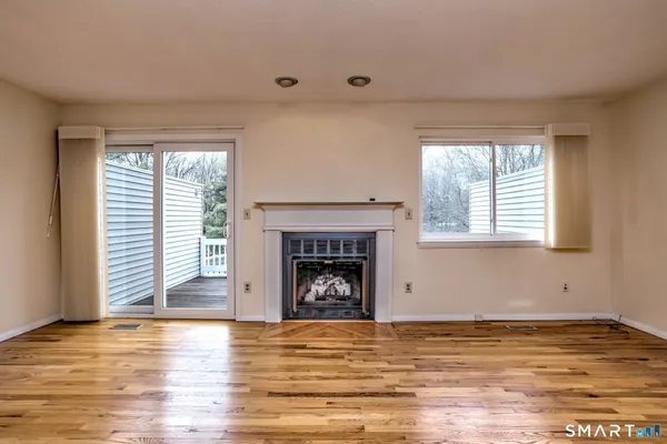 a view of an empty room with window and fire place