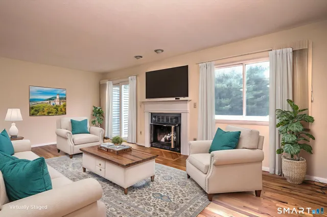 a living room with furniture a flat screen tv and a fireplace