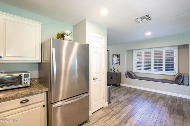 a kitchen with stainless steel appliances a refrigerator sink and wooden floor