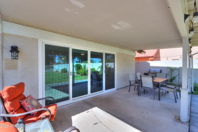 a living room with patio furniture and a floor to ceiling window
