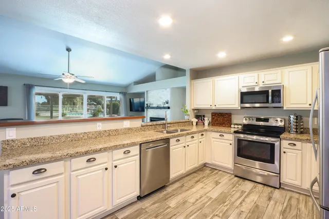 a kitchen with stainless steel appliances granite countertop a stove a sink and a microwave