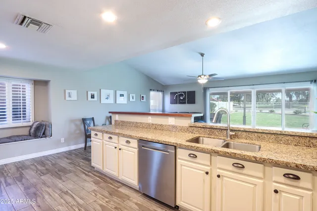 a open kitchen with granite countertop a sink and a stove top oven