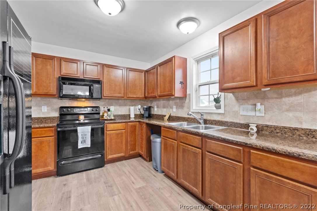 699 Cape Fear Road Raeford, NC 28376 - Photo 4 of 35 a kitchen with stainless steel appliances granite countertop a stove a sink dishwasher and a microwave oven with cabinets