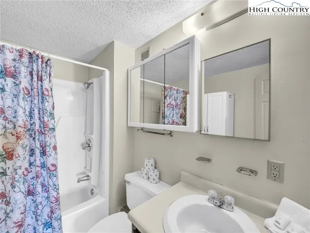 a bathroom with a bathtub shower sink vanity and mirror