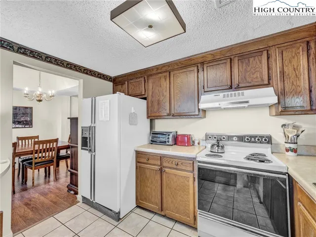 a kitchen with a white stove top oven and refrigerator