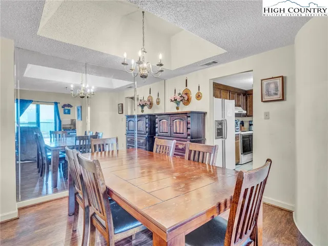 a dining room with furniture a chandelier and wooden floor