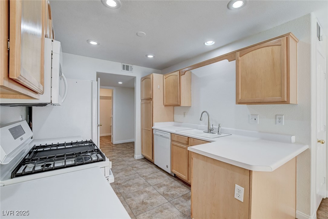 511 Rafkin Place Henderson, NV 89052 - Photo 20 of 64 Kitchen featuring light brown cabinets, white appliances, light countertops, recessed lighting, and a peninsula