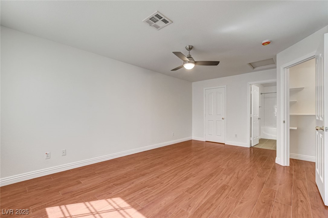 511 Rafkin Place Henderson, NV 89052 - Photo 33 of 64 Unfurnished bedroom featuring attic access, light wood-type flooring, ceiling fan, and ensuite bathroom