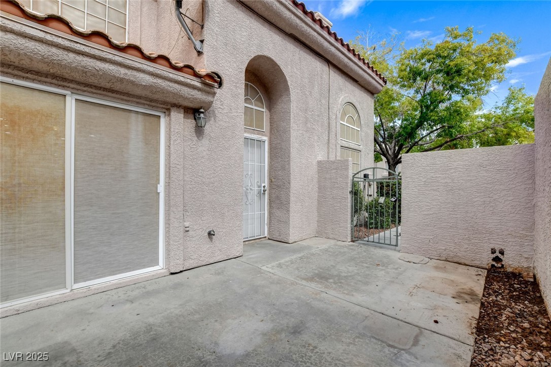 511 Rafkin Place Henderson, NV 89052 - Photo 7 of 64 Doorway to property featuring a gate, a patio, a tile roof, and stucco siding