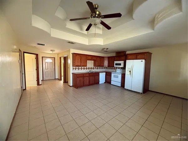 a view of an empty room and kitchen