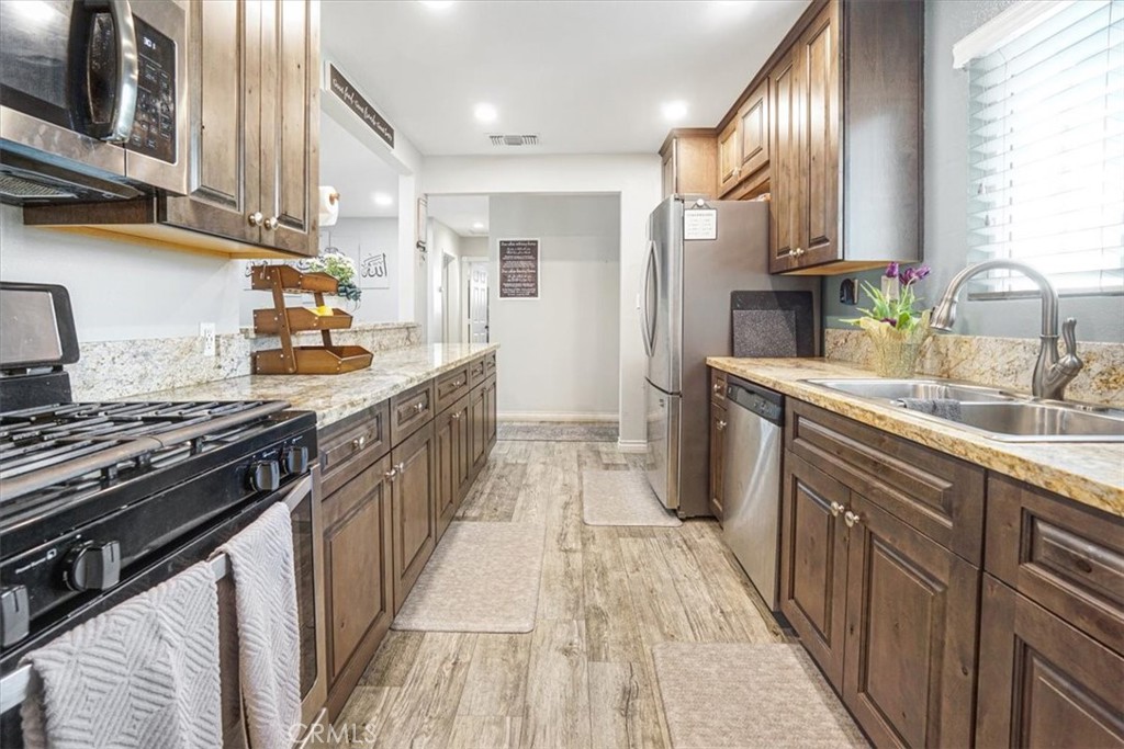 33962 Clark Lane Yucaipa, CA 92399 - Photo 2 of 48 a kitchen with stainless steel appliances a sink stove and cabinets