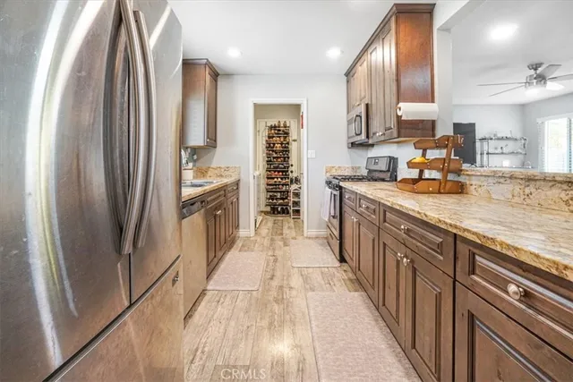 a kitchen with stainless steel appliances granite countertop a refrigerator and a stove