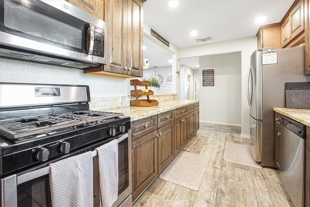 33962 Clark Lane Yucaipa, CA 92399 - Photo 4 of 48 a kitchen with stainless steel appliances and a stove top oven
