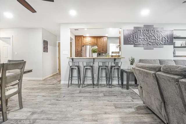 a living room with furniture a wooden floor and a kitchen view