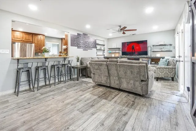 a living room with furniture a flat screen tv and kitchen view