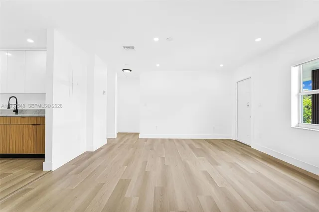 a view of a room with wooden floor and a sink