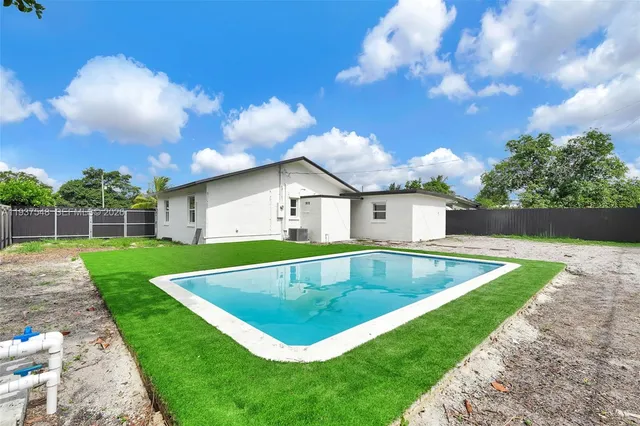 a view of a house with a swimming pool and a yard
