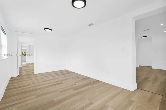 a view of empty room with wooden floor