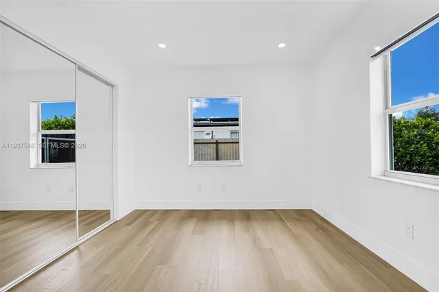 a view of a room with wooden floor and a window