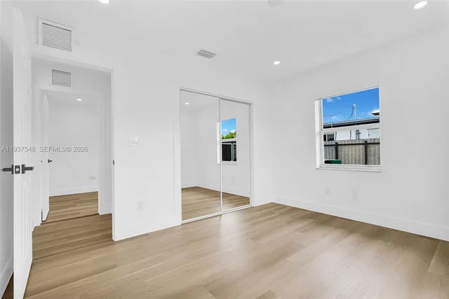 a view of an empty room with wooden floor