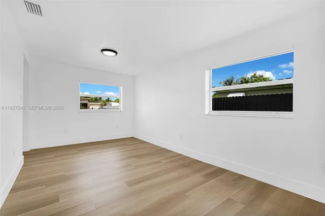 a view of empty room with wooden floor