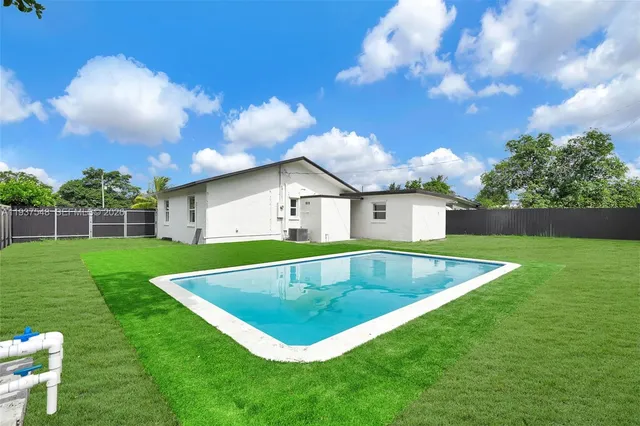 a view of a house with a swimming pool and a yard