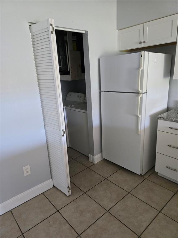 214 Boundary Boulevard, Unit B Rotonda West, FL 33947 - Photo 5 of 6 a view of a refrigerator in kitchen and an empty room with wooden floor