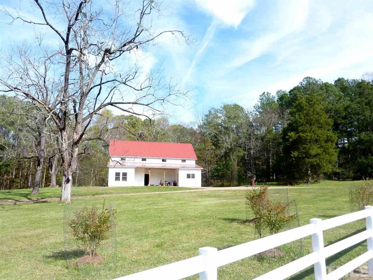 1519 Pleasant Green Road Durham, NC 27705 - Photo 28 of 30 This barn was built on a slab with a loft, open framing and has been used as a machine/wood shop. Very easy to add stalls for horses or livestock.There are two offices at the front. Bushes in cages are Blueberries, yum. There are pear,cherry,fig and peach