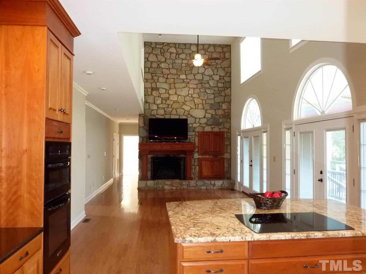 1519 Pleasant Green Road Durham, NC 27705 - Photo 10 of 30 Opens to the kitchen with Romeo and Juliet doors from second floor. Floor to ceiling fireplace w/ gas logs or remove them and burn wood. Outlets in floor. Wall of windows look out on the deck and backyard.