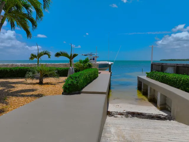 a view of a house with a yard and potted plants