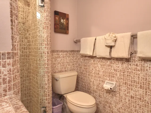 a white toilet sitting next to a white wall