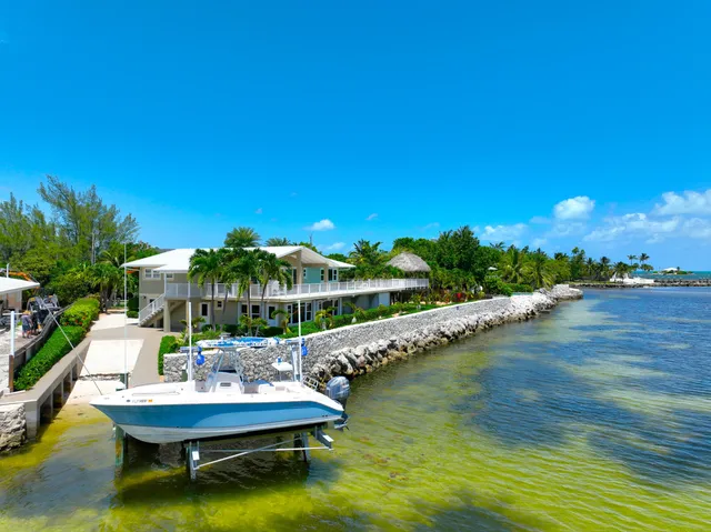 a view of a house with pool and chairs