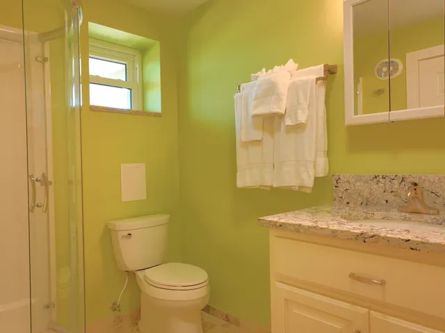 a bathroom with a granite countertop toilet sink and mirror