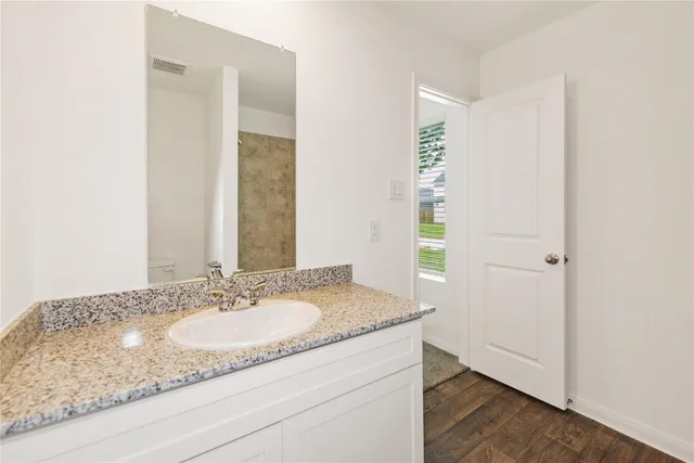 a bathroom with a granite countertop sink and a mirror